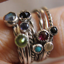 Load image into Gallery viewer, Stack of silver rings with gemstones on a finger