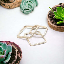 Load image into Gallery viewer, A set of three sterling silver rings with a hammered texture, displayed on a white surface with plant decoration in the background.
