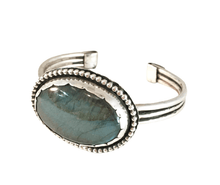 Load image into Gallery viewer, A sterling silver cuff bracelet featuring a large labradorite stone, with intricate silver detailing around the band.